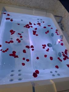 un tavolo bianco con fiori rossi di L'Eclipse maison romantique avec Jacuzzi 