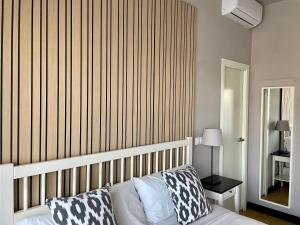 1 dormitorio con cama y pared a rayas en MD Modern Hotel - Jardines en Valencia