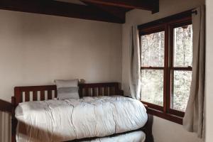 Schlafzimmer mit einem Bett und einem Fenster in der Unterkunft Blueberry Hideaway at 36 North Cabin - Hot Tub in Purlear