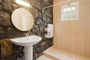 a stone bathroom with a sink and a mirror at Casa Catarina in Junqueira