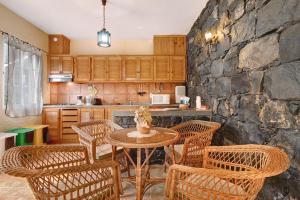 uma cozinha com uma mesa e cadeiras e uma parede de pedra em Casa Catarina em Junqueira