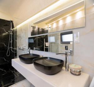 a bathroom with two black sinks on a counter at Filia's Memories Apartments in Agios Nikolaos