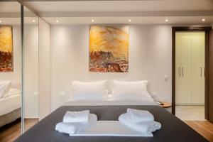 Filia's Memories Apartments في آغيوس نيكولاوس: غرفة نوم بسرير كبير ومخدات بيضاء