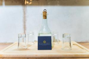 una botella de vino en una tabla de cortar con dos copas en Filia's Memories Apartments en Agios Nikolaos