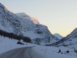 a road in the middle of a snow covered mountain at Lunheim in Geiranger in Geiranger
