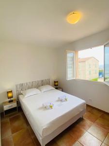 una camera da letto con un grande letto bianco e una finestra di "T4 Anghjula Santa" proche du port avec vue mer a Sari Solenzara