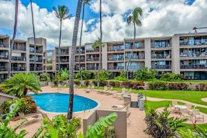 an apartment complex with a pool and palm trees at Hale Ono Loa Condo in Kahana