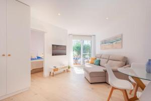 biały salon z kanapą i stołem w obiekcie FARO PUERTO ESTEPONA w mieście Estepona