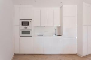 a white kitchen with a sink and a microwave at FARO PUERTO ESTEPONA in Estepona