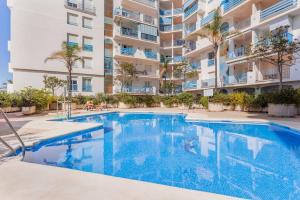 a swimming pool in front of a apartment building at FARO PUERTO ESTEPONA in Estepona