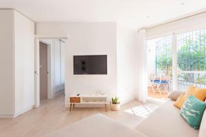 uma sala de estar branca com um sofá e uma televisão em FARO PUERTO ESTEPONA em Estepona