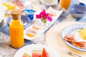 uma mesa com pratos de comida e uma garrafa de sumo de laranja em La Barranca de la Barca em Alora
