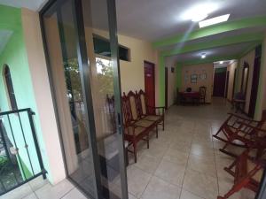 - un couloir d'une maison avec des chaises et des portes en verre dans l'établissement Hostal San Antonio, à León