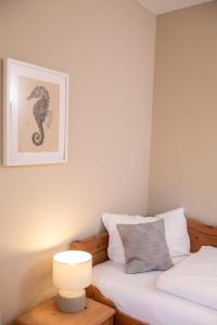 Schlafzimmer mit einem Bett mit einem Seepferdchen-Bild an der Wand in der Unterkunft Das Anni's in Wangerland