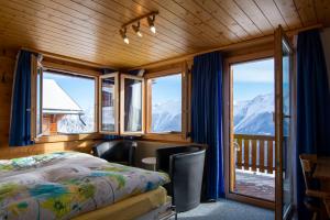 a bedroom with a bed and views of mountains at Chalet Weisshorn 5 in Bettmeralp