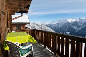 a balcony with a table and chairs and mountains at Chalet Weisshorn 5 in Bettmeralp