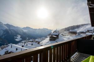 a view from a balcony of a village with snow covered roofs at Chalet Weisshorn 5 in Bettmeralp