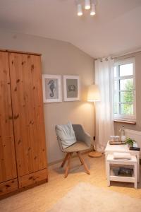 uma sala de estar com uma cadeira e um armário em Das Anni's em Wangerland