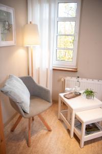 uma sala de estar com uma cadeira e uma mesa em Das Anni's em Wangerland