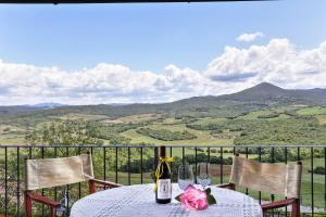uma mesa com uma garrafa de vinho e dois copos em Borgo di Monte Murlo em Guardistallo