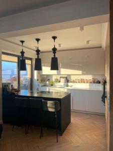Luxury penthouse with Kosice view في كوشيتسه: مطبخ مع جزيرة سوداء في الوسط