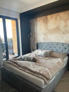 1 cama grande en un dormitorio con una pared azul en Luxury penthouse with Kosice view, en Košice