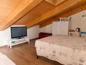 een slaapkamer met een bed en een flatscreen-tv bij Oasi dei Deserti - Camera con colazione in Morciano di Romagna