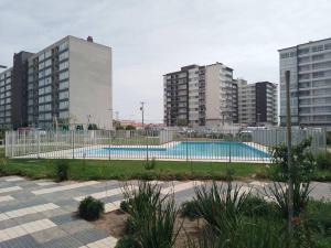 ein Schwimmbad in einer Stadt mit hohen Gebäuden in der Unterkunft Departamento amoblado, 2 piezas 1 baño, 6º piso con ascensor, vista norte, control 24 hr in La Serena