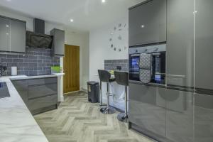 a kitchen with stainless steel appliances and wooden floors at Vion Apartment- Westerton in Aberdeen