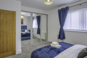 1 dormitorio con cama y espejo grande en Vion Apartment- Westerton, en Aberdeen