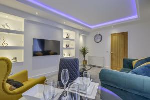 a living room with a blue couch and chairs at Vion Apartment- Westerton in Aberdeen