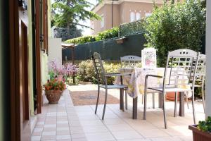 une table et des chaises assises sur une terrasse dans l'établissement La Casa dei Nonni sul Garda, à Peschiera del Garda