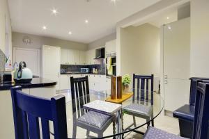 uma cozinha com uma mesa de vidro e cadeiras em Beach Way House em Southbourne