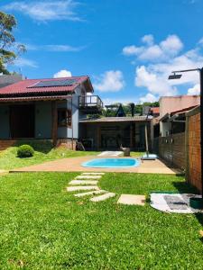 a backyard with a swimming pool and a house at chalé da reserva com piscina in Torres