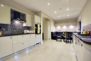 uma cozinha com armários brancos e uma sala de jantar em Beach Way House em Southbourne
