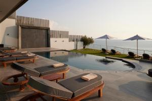 a swimming pool with lounge chairs and a swimming pool at Villa OMNIA - Luxury Bound on Earth in Nea Moudania