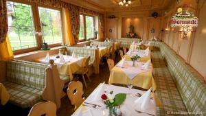 a restaurant with white tables and chairs and windows at Hotel-Gasthof-Sonneck in Reit im Winkl