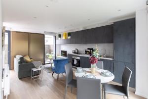 ロンドンにあるhomely - Central London Camden Penthouse Apartmentのキッチン、リビングルーム(テーブル、椅子付)