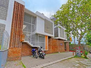 a motorcycle parked in front of a brick building at SUPER OYO 2190 Alamanda 7 Syariah in Bandung