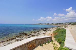 a view of the ocean with a stone wall at Villa Lata in Marina San Gregorio