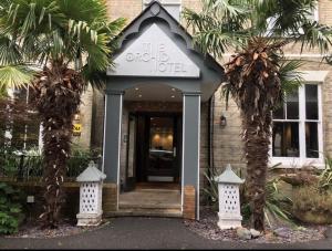 a hotel entrance with palm trees in front of it at The Orchid Hotel in Bournemouth