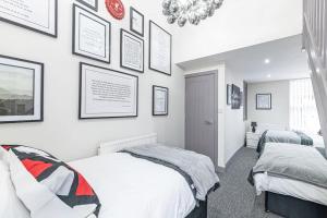 two beds in a bedroom with pictures on the wall at Accommodation for Liverpool Football in Liverpool