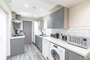 a white kitchen with a washer and dryer in it at Accommodation for Liverpool Football in Liverpool