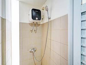 a shower in a bathroom with a tv on the wall at SUPER OYO 2190 Alamanda 7 Syariah in Bandung
