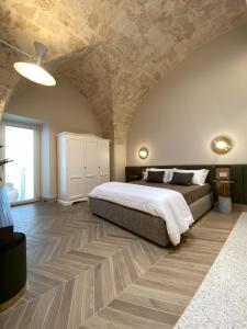 a bedroom with a large bed and a stone ceiling at Dimore Garibaldi - Puglia Mia Apartments in Monopoli