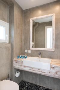 a bathroom with a sink and a mirror at Poseidon Blue Gastronomy Hotel in Afiartis +37 photos
