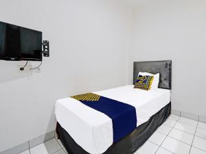 a bedroom with a bed and a flat screen tv at SUPER OYO 2190 Alamanda 7 Syariah in Bandung