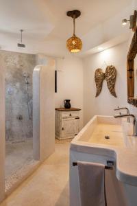 a bathroom with a shower and a sink at El Corazón Boutique Hotel - Adults Only with Beach Club pass included in Holbox Island