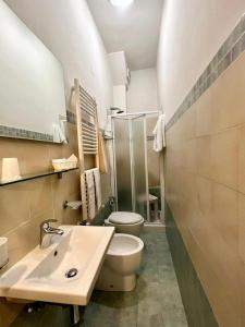 La salle de bains est pourvue de toilettes blanches et d'un lavabo. dans l'établissement Hotel Centrale, à Cascia