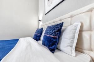 Una cama con almohadas azules y blancas. en Прекрасная квартира в центре левого берега, en Astana